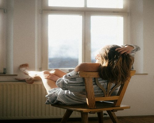 Eine Person schaut entspannt aus dem Fenster