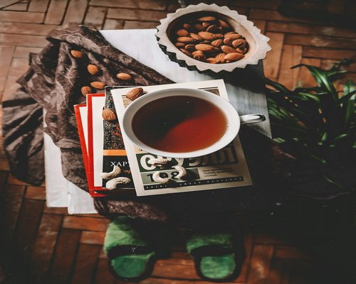 Eine Tasse Tee neben einem aufgeschlagenen Buch